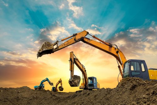 Four,Excavators,Work,On,Construction,Site,At,Sunset